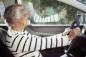 Side view of senior woman sitting on driver seat in car