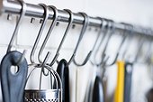 Close-up of kitchen utensils hanging on rod