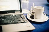 Close-up of laptop and tea cup in office