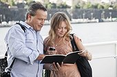 Mature couple looking at notebook outdoors