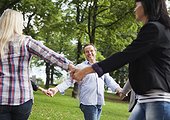 Mature group of people holding hands in park