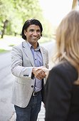 Happy mature businessman shaking hands with woman