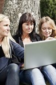 Mature female business co-workers with laptop outdoors