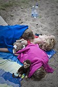 Mother with two children sleeping on beach