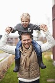 Portrait of father giving ride to son on shoulders