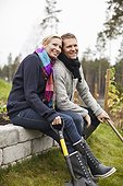 Man and woman sitting in back yard with gardening tools