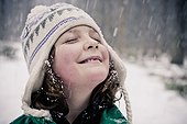 Smiling young girl enjoying in snowfall
