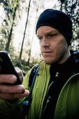 Man text messaging in forest