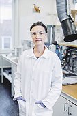 Portrait of confident female scientist standing with hands in pockets at laboratory