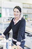 Portrait of smiling female scientist standing in laboratory