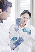 Male and female scientists examining sample in laboratory