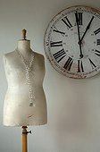 Old wall clock and tailors dummy with necklace