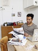 Man reading newspaper at home