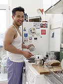 Smiling man in kitchen making coffee