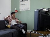 Man watching TV with beer and chips