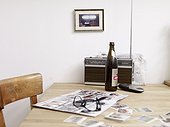 Beer bottle, eyeglasses and album with soccer collector cards on table