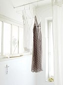 Two nightdresses hanging in bathroom