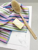 Bar of soap and back brush on striped towel