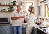 Elderly couple, coffee and kitchen smile, conversation and morning together in their home. Man, woman and retirement in house bonding, happy and relax, talking at breakfast to start day or routine