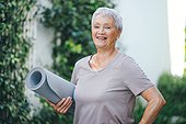 Fitness is a lifestyle. Portrait of an older woman holding an exercise mat before her workout outside.