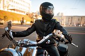 Biker in leather jacket and helmet with visor