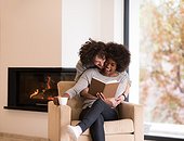 multiethnic couple hugging in front of fireplace