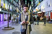 Man using his cell phone in the city at night