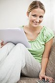portrait of young woman at home reading letter