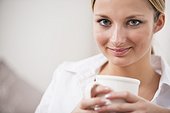 headshot of young woman holding coffee cup