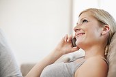 portrait of young woman at home talking on mobile phone