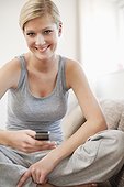 portrait of young woman at home with mobile phone