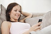 portrait of young woman at home with mobile phone