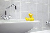 overflowing sink in bathroom with yellow rubber duck