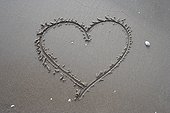 heart drawn in sand on beach