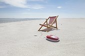 sunlounger and computer mouse on sandy beach