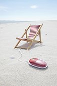 sunlounger and computer mouse on sandy beach