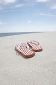 pair of flip flos on sandy beach