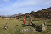 a man stands in a stone circle; lauragh county kerry ireland