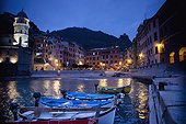 boats moored by buildings along the waterfront at night; vernazza liguria italy