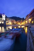 boats moored by buildings along the waterfront at night; vernazza liguria italy