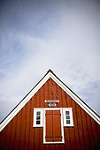 a red wooden building with shutters on the window and a peaked rooftop; papey island iceland