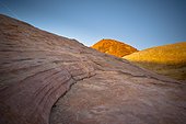 sunlight shining on red rock with a blue sky above; nevada united states of america