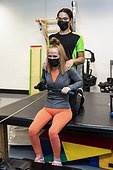 A paraplegic woman working out on a rowing machine with her trainers; Edmonton, Alberta, Canada