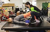A paraplegic woman doing assisted hip thrusters with her trainer: Edmonton, Alberta, Canada