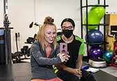 A paraplegic woman and trainer celebrating the day's accomplishment by posting on social media: Edmonton, Alberta, Canada