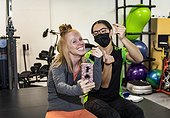 A paraplegic woman and trainer celebrating the day's accomplishment by posting on social media while clicking their fingers: Edmonton, Alberta, Canada