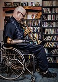 Man with double limb amputations playing the trumpet at home; St. Albert, Alberta, Canada