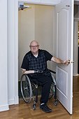 Man with double limb amputations entering home elevator; St. Albert, Alberta, Canada