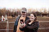 A mom with epilepsy taking a self-portrait with her son who has Aspberger Syndrome at an equine centre; Westlock, Alberta, Canada