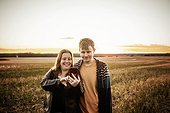 A mother with epilepsy taking a self-portrait with her son who has Aspberger Syndrome in a field on a farm after harvest; Westlock, Alberta, Canada